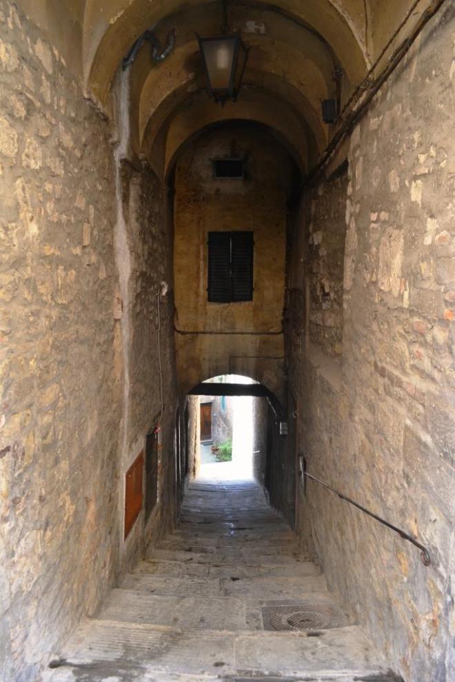 Door at the end of a passageway off Via Nazionale, Cortona, Umbria, Italy