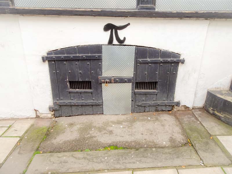 Cellar doors with the addition of a metal strip and a tag by tagger Pi who seems to have tagged every street in Bristol, November 2019