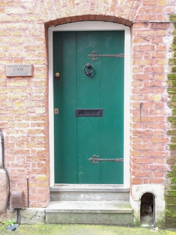 Green door with a boot scraper, Bristol, December 2019