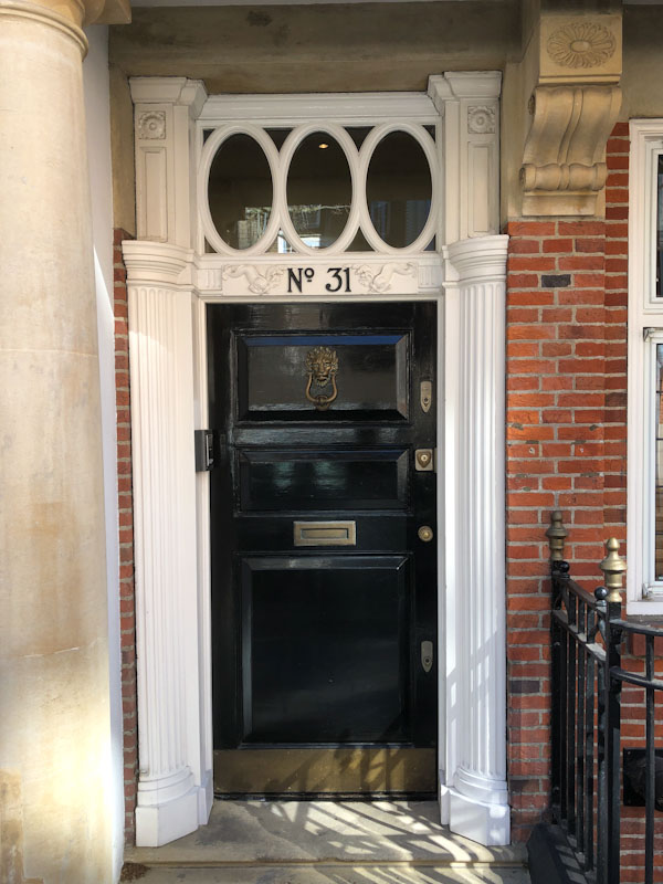 Black door with a stunning carved timber surround , Westminster, London, April 2022