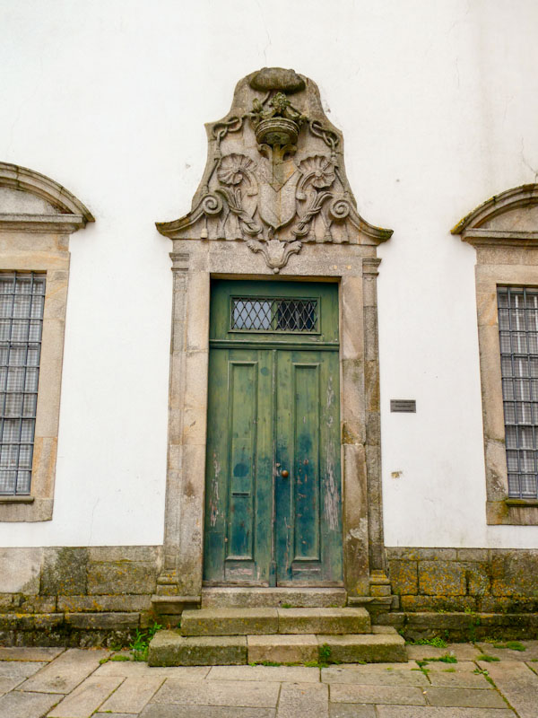 Large green door with ornate stone surround, Porto, Portugal, June 2022