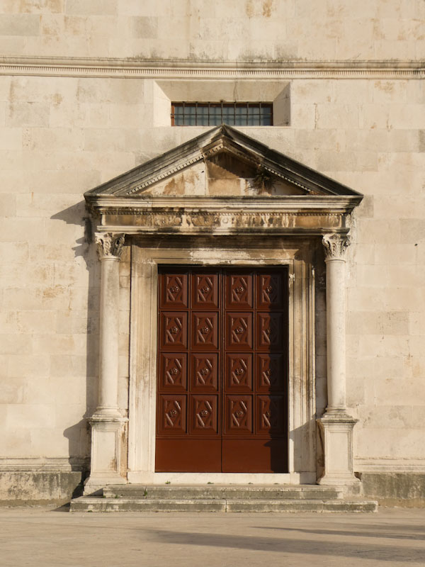 Church door with a pediment over it, Zadar, Croatia, August 2022