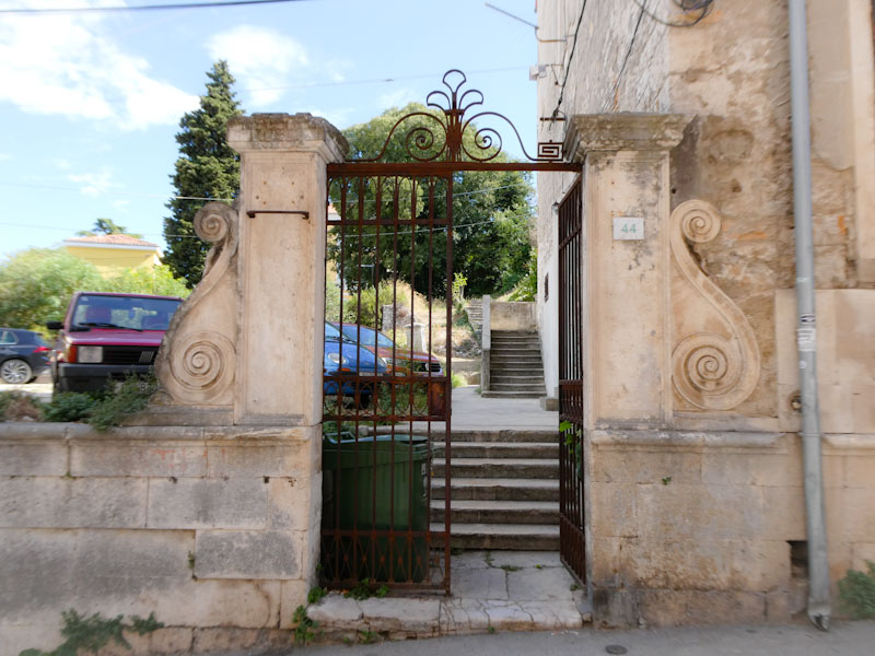 Ornate stonework and iron gate, Pula, Croatia, August 2023