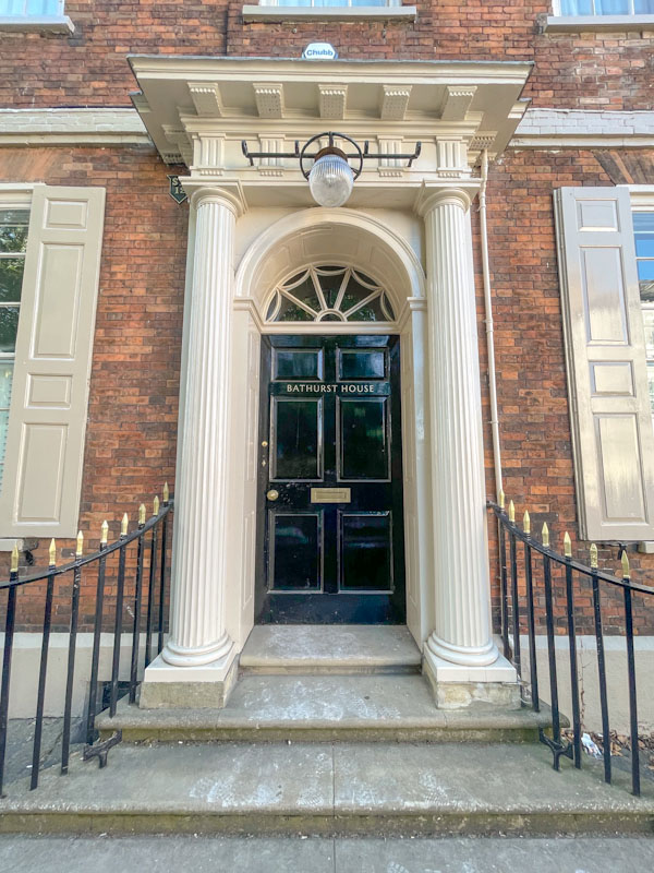 Black door with very grand columns and portico, York, June 2023