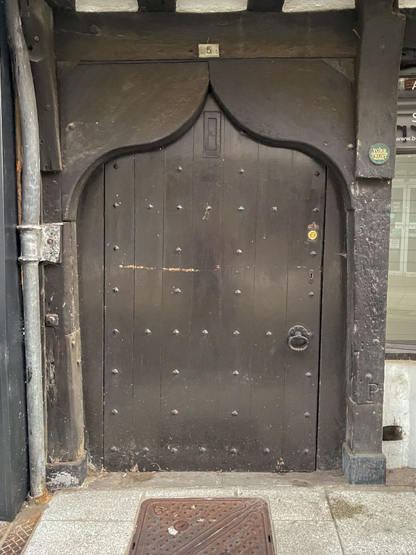 Tudor doorway and more recent door, York, June 2023