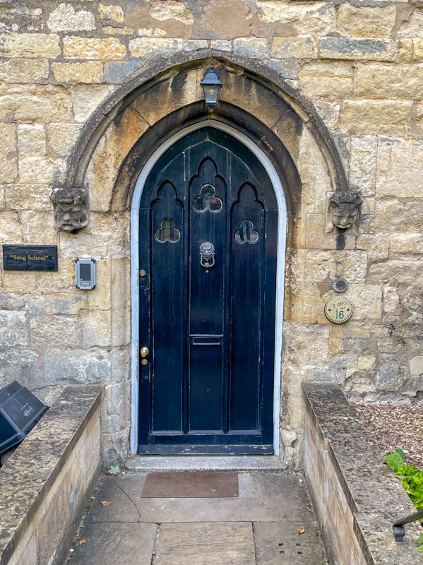 Black door with clover leaf shaped windows, Lincoln, July 2023