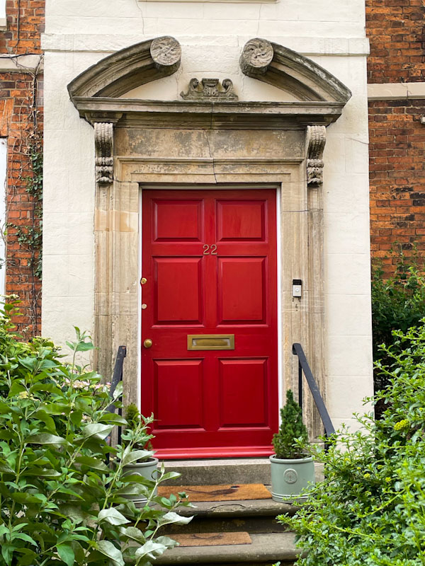 Red door and open segmental pediment, Lincoln, July 2023