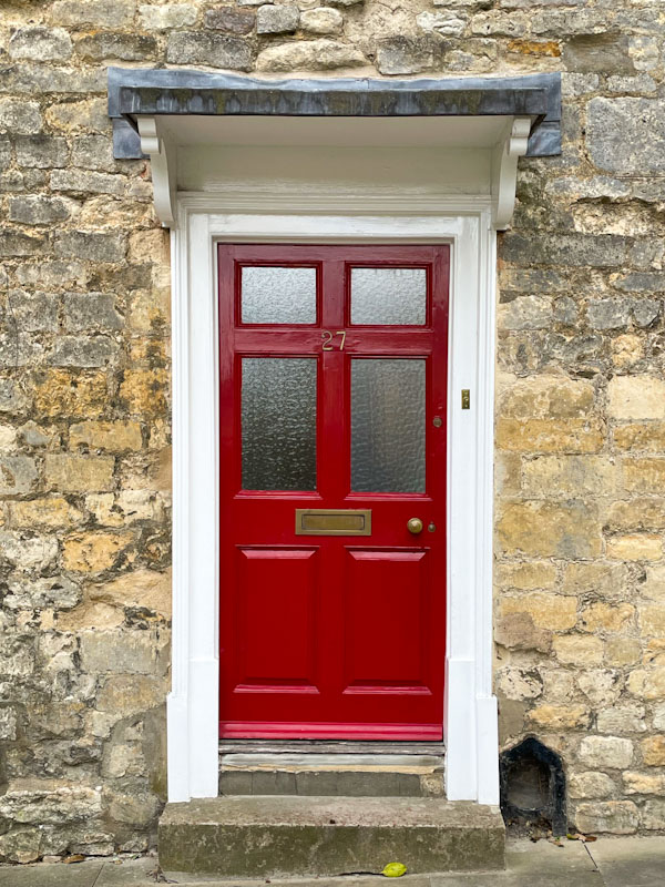Red door with flat roofed awning, Lincoln, July 2023