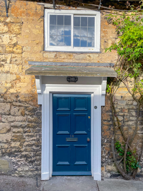 Blue door and reflected cloudes in the window, Lincoln, July 2023