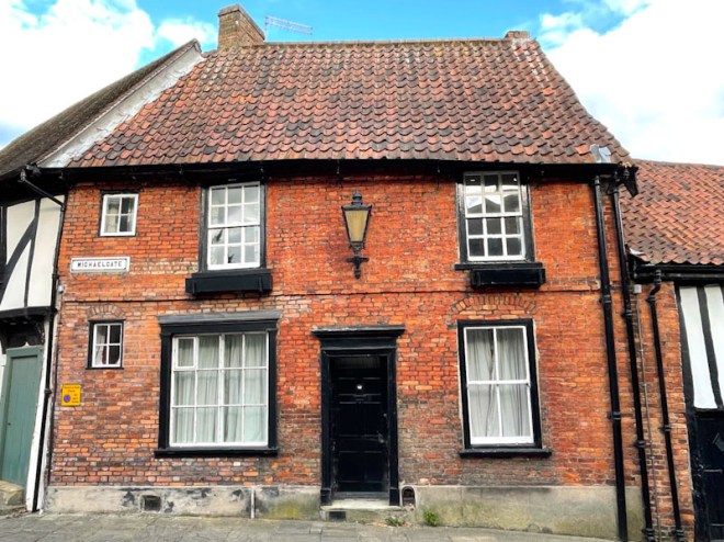 Black door on a red-brick building, Lincoln, July 2023