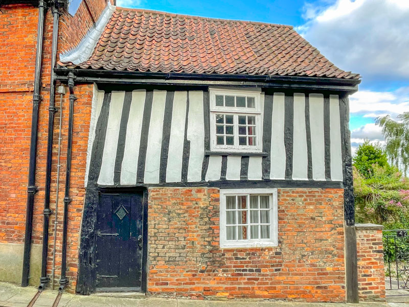Black door on a red-brick/timber-framed building, Lincoln, July 2023