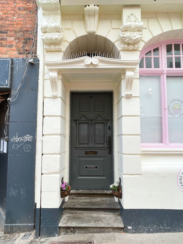 Door with awning and pigeon discouragement, Lincoln, July 2023