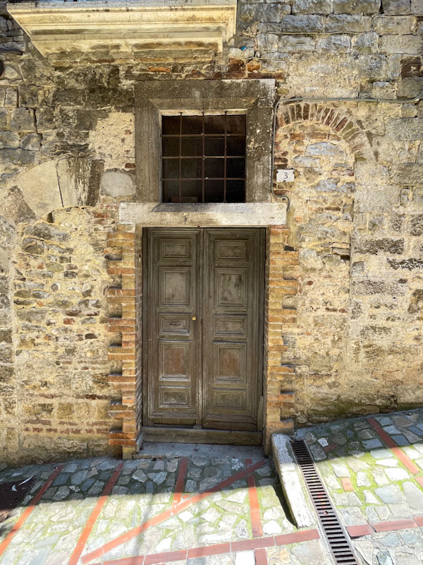 Wooden panelled door between two ghost doors, Todi, Umbria, Italy, July 2023