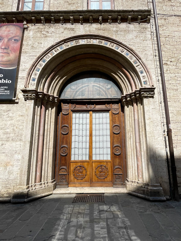 Beautiful arched doorway and carved wooden doors, Perugia, Umbria, Italy, July 2023