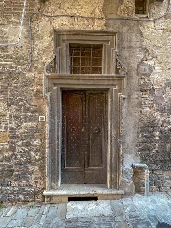 Old door with rivets and fine stonework, Perugia, Umbria, Italy, July 2023