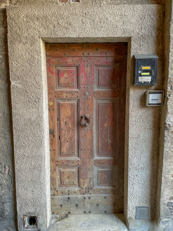 Studded old door and modern concrete frame, Perugia, Umbria, Italy, July 2023