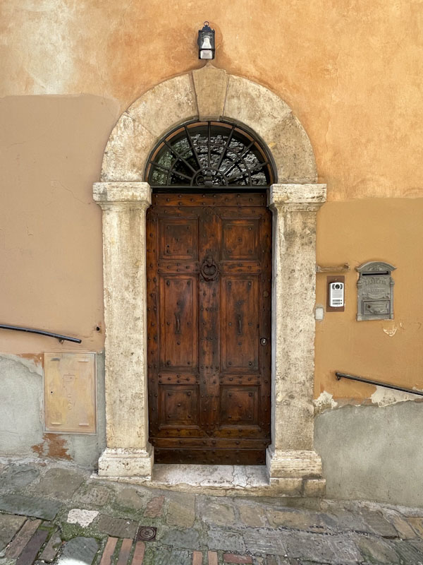 Fine wooden door and parched colours of an Italian dusty summer, Perugia, Umbria, Italy, July 2023