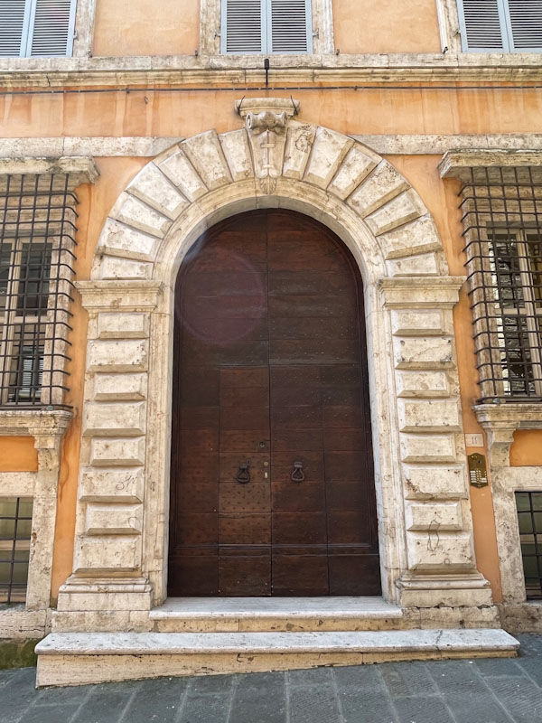 Double doors within doors and an impressive stone archway. Perugia, Umbria, Italy, July 2023