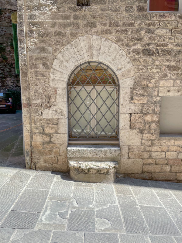 I'm not sure if his window had once been a door, the frame might suggest so, Perugia, Umbria, Italy, July 2023