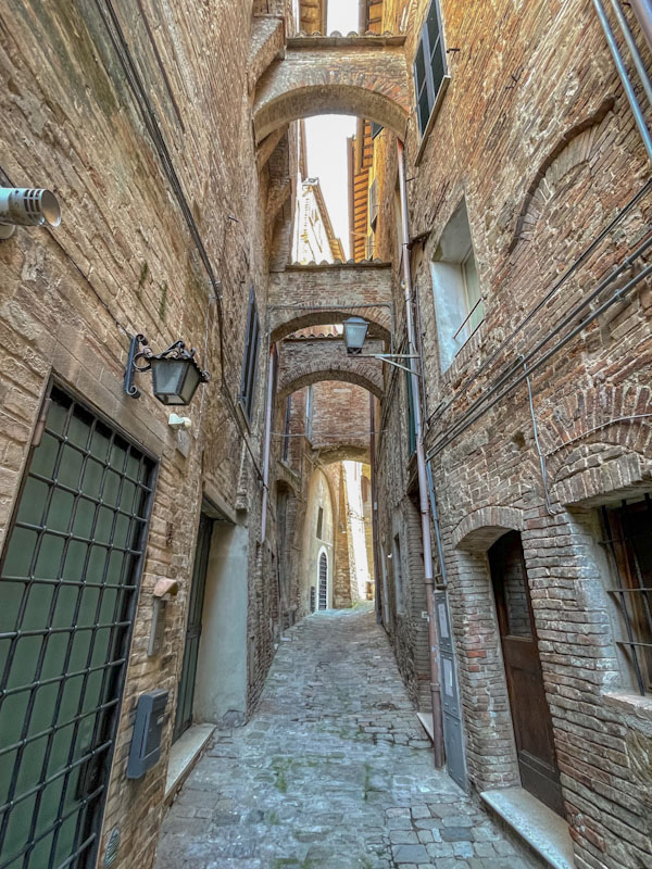 More cheeky doors in this alleyway with structural arch braces, Perugia, Umbria, Italy, July 2023
