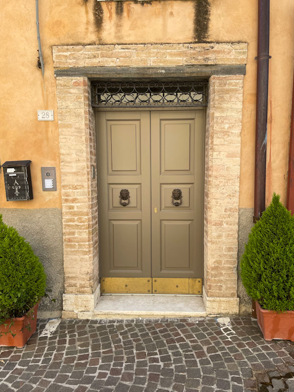 Doors with brick surround, Montefalco, Umbria, Italy, July 2023