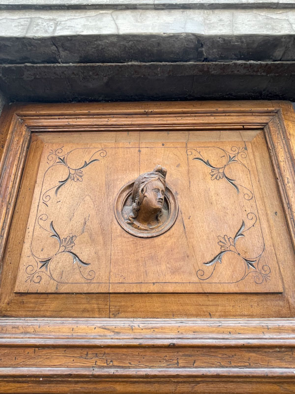 Wooden door with beautiful carvings (detail), Montefalco, Umbria, Italy, July 2023