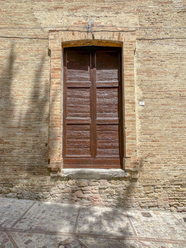Door set high above the pavement, Montefalco, Umbria, Italy, July 2024