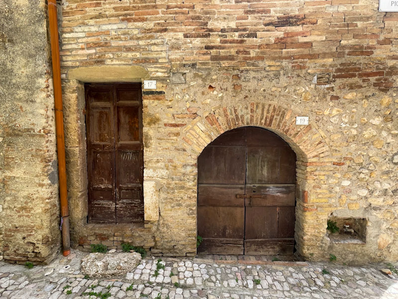 A pair of doors and street tap, Montefalco, Umbria, Italy, July 2024