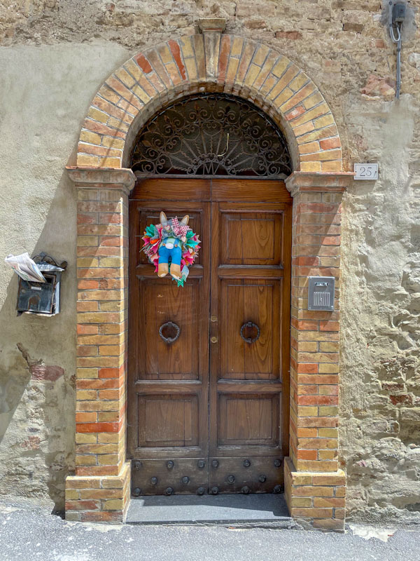 Door with a bunny-bottom garland, Montefalco, Umbria, Italy, July 2024