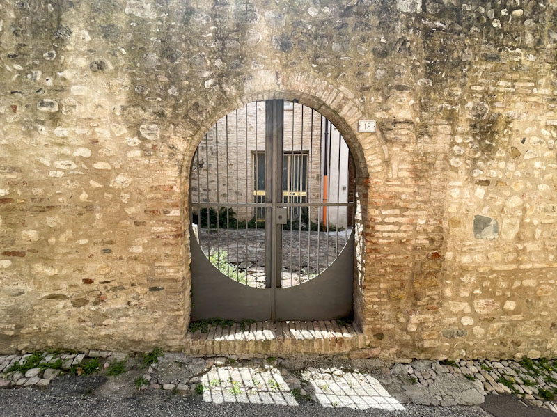 Beautiful gate and door behind, Montefalco, Umbria, Italy, July 2023