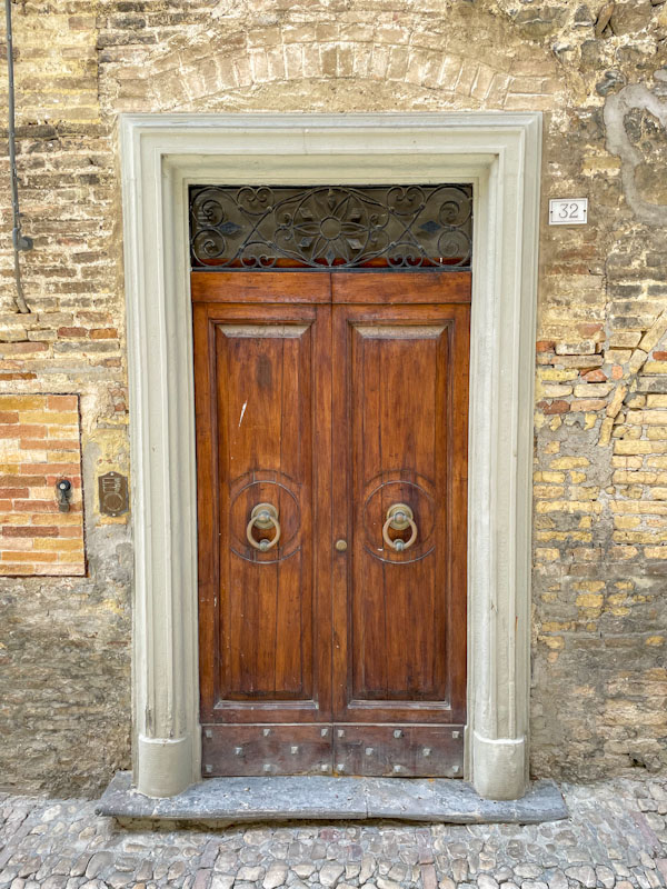 Fine double door in a former arched doorway, Montefalco, Umbria, Italy, July 2023