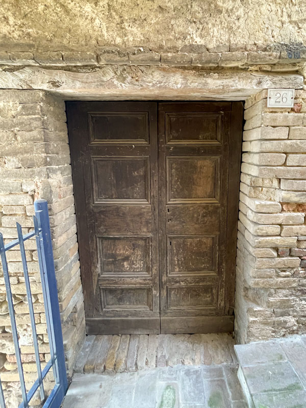 Small double doors and wooden lintel, Montefalco, Umbria, Italy, July 2023