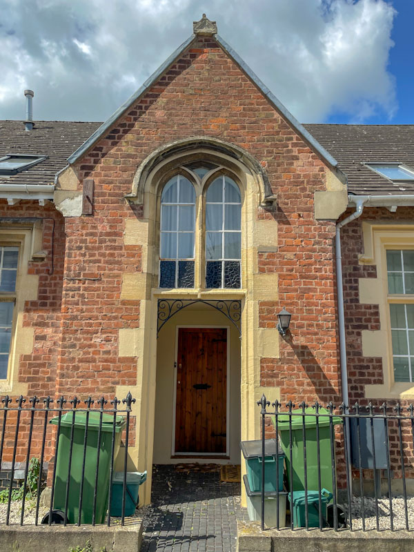Recessed door with a fine stone archway and windows, Cheltenham, July 2023