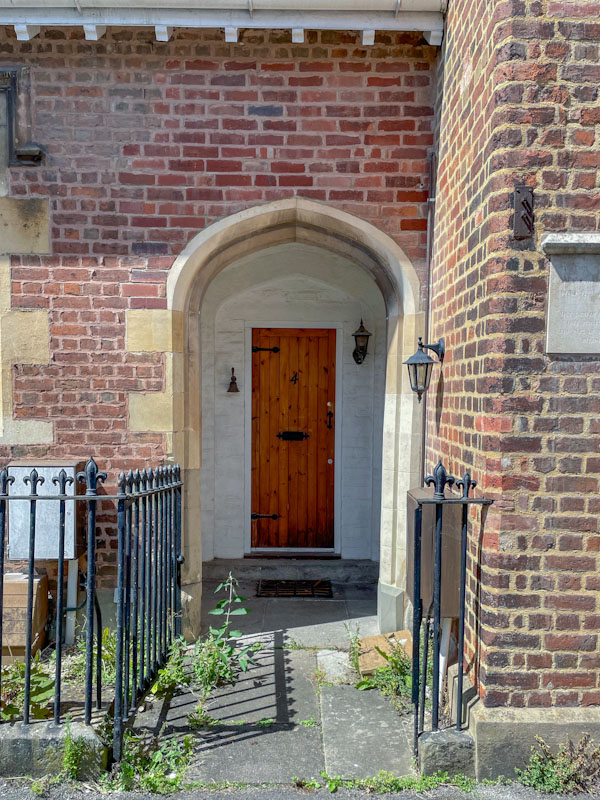 Recessed wooden door with a fine stone archway, Cheltenham, July 2023