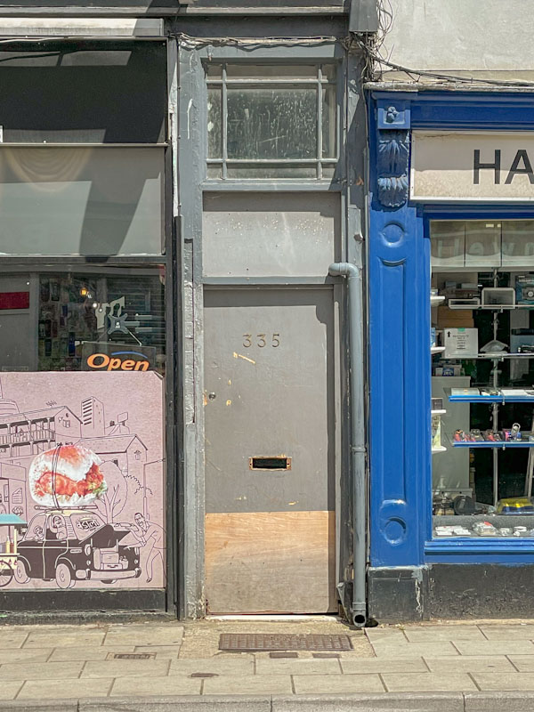 Grey, tatty door, Cheltenham, July 2023