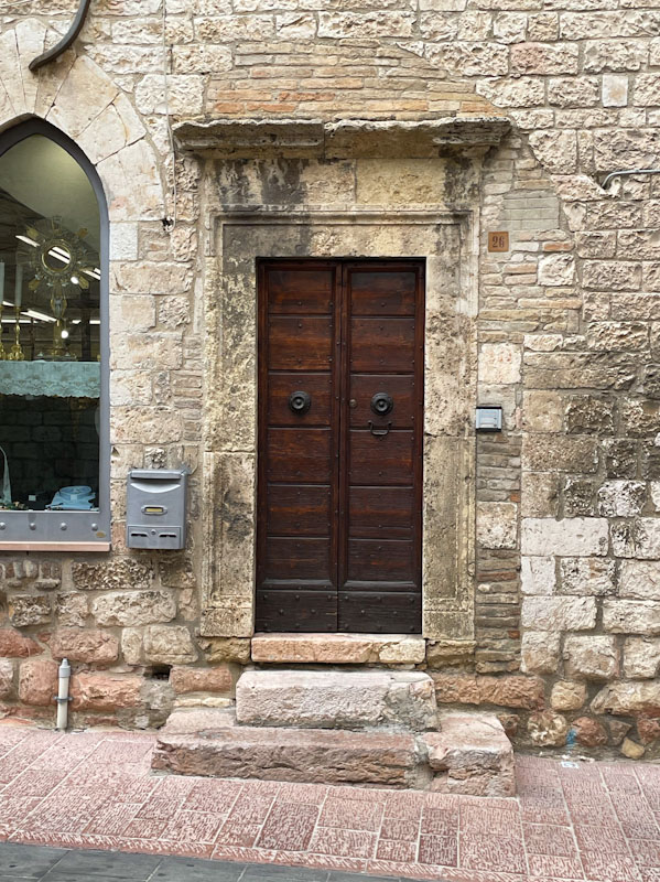 fine wooden doors and stunning stone surround, Assisi, Umbria, Italy, July 2023