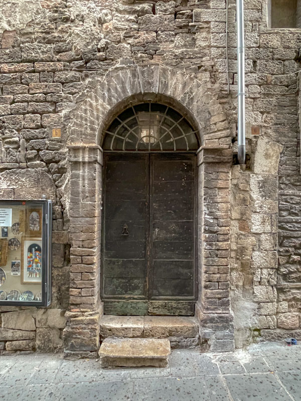 Wooden doors, stone steps, Assisi, Umbria, Italy, July 2023