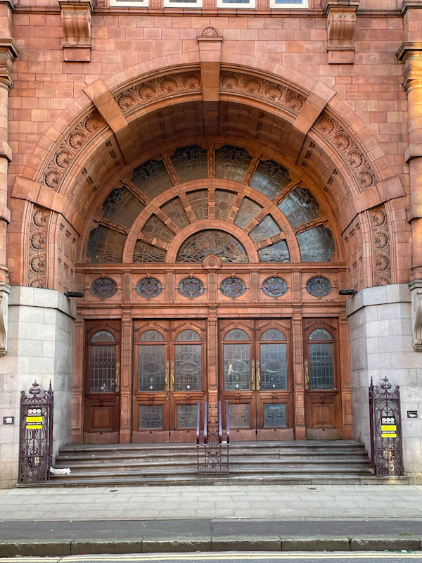 Magnificent doorway and doors to redbrick building, Manchester, November 2023