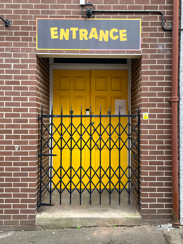 Yellow door behind a gate, Nottingham, March 2024