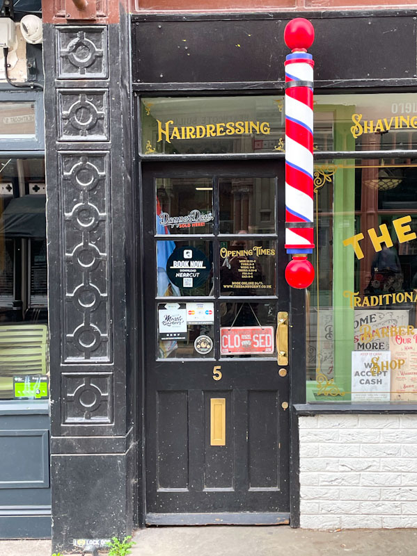 Black door and barber's pole, Nottingham, March 2024