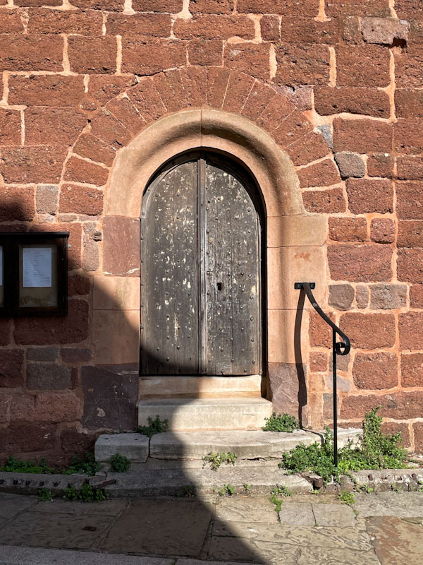 Church door with characteristic Devon red sand stone walls, Exeter, October 2023