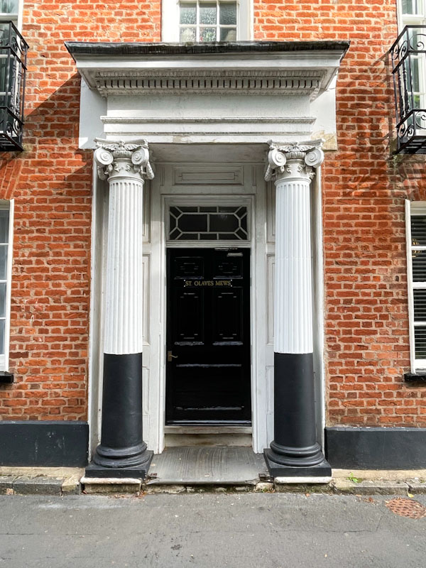 Black door and grand entrance with portico and ionic columns, Exeter, October 2023