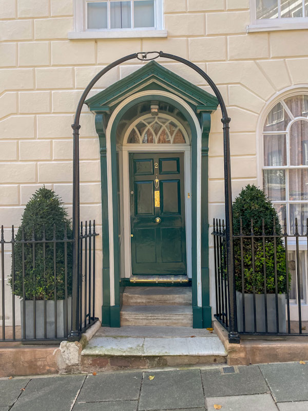 Formal doorway with portico and wonky door, Exeter, October 2024