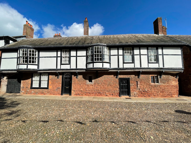 Black doors in a long building, Exeter, October 2024