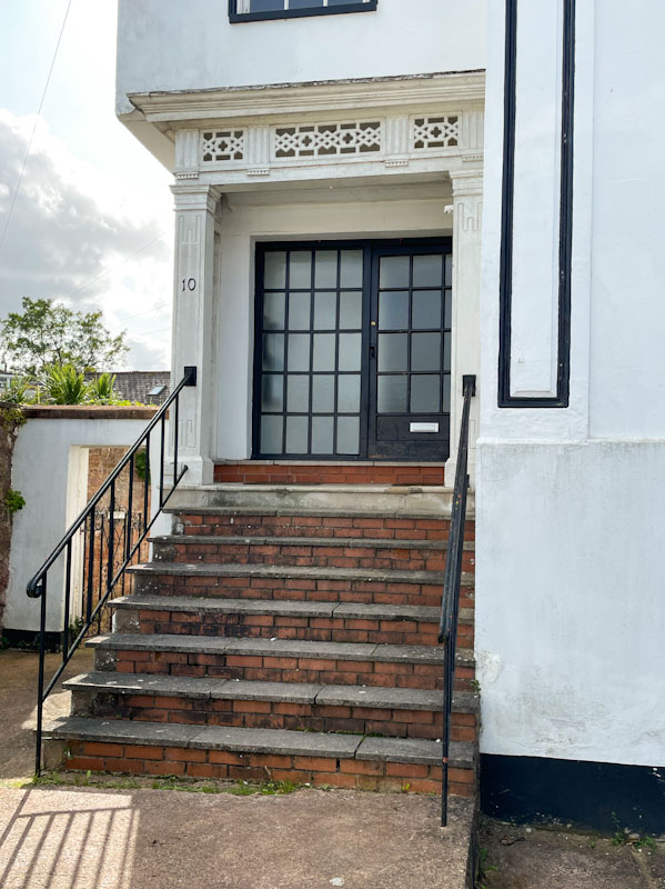 Functional black glass-panelled door and fancy surround, Exeter, Devon, October 2023