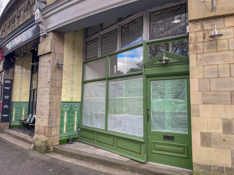 Beautiful shopfronts with green doors and superb tile work., Buxton, Derbyshire, April 2024