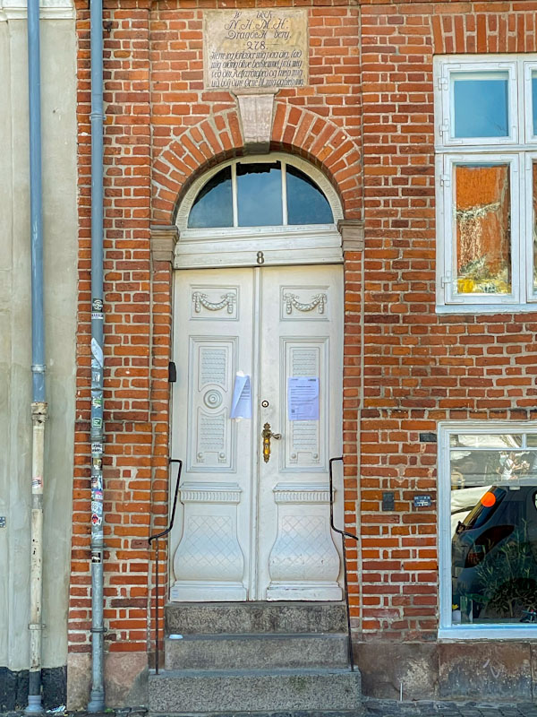 Beautiful old door and wonky doorway complete with irritating notices, Nyhavn, Copenhagen, Denmark, September 2024
