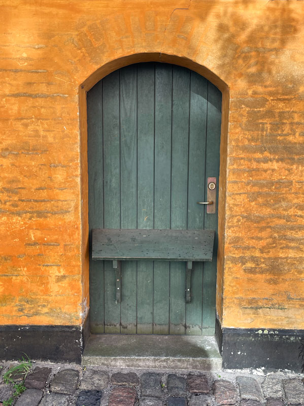 Green door with perch, Store Kongensgade, Copenhagen, Denmark, September 2024