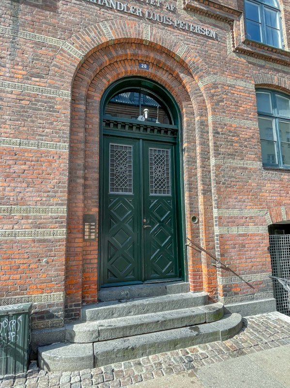 Black doors in an arched doorway, Viktoriagade, Copenhagen, Denmark, September 2024