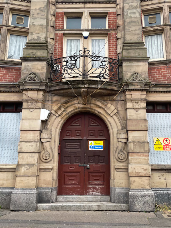Large arched door with ornate balcony, Leicester, Leicestershire, May 2024